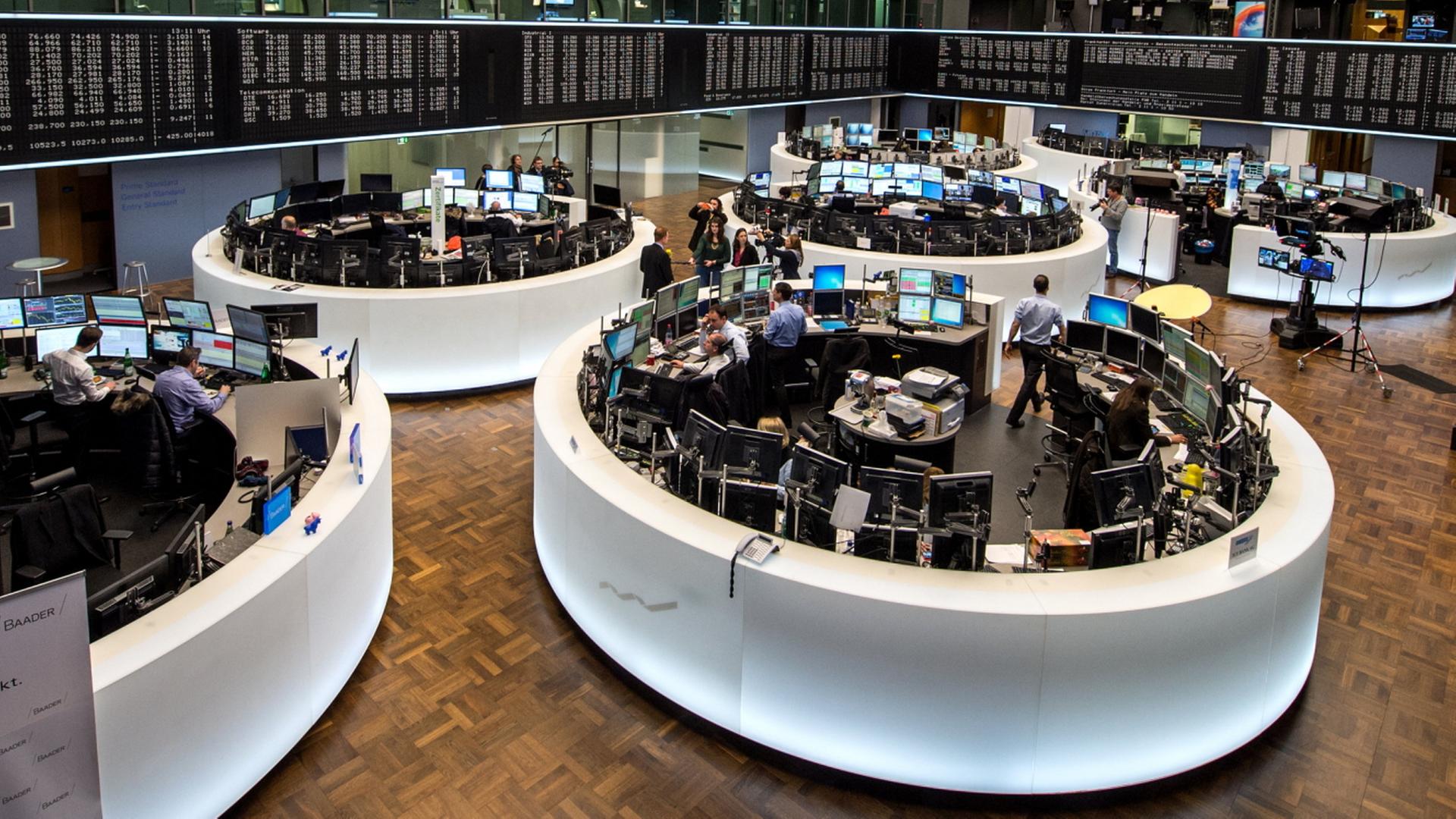 Menschen arbeiten auf dem Börsenparkett in Frankfurt. | dpa