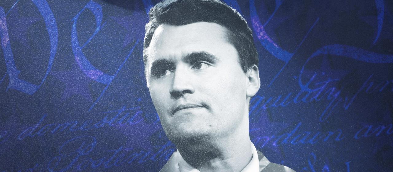 Eine Person hält ein Bild von Charlie Kirk.
