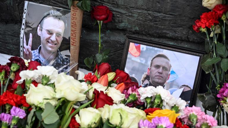 Blumen liegen neben Fotos des verstorbenen Oppositionellen Alexej Nawalny in Moskau