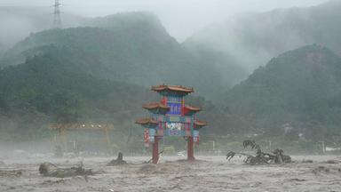 Ein traditionelles Tor wird in China von Hochwasser umgeben.