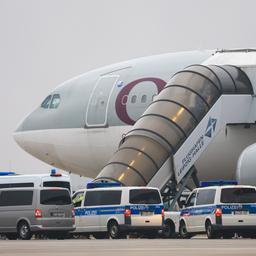 Ein Qatar Airways Flugzeug am Flughafen Leipzig/Halle und Polizeifahrzeuge.