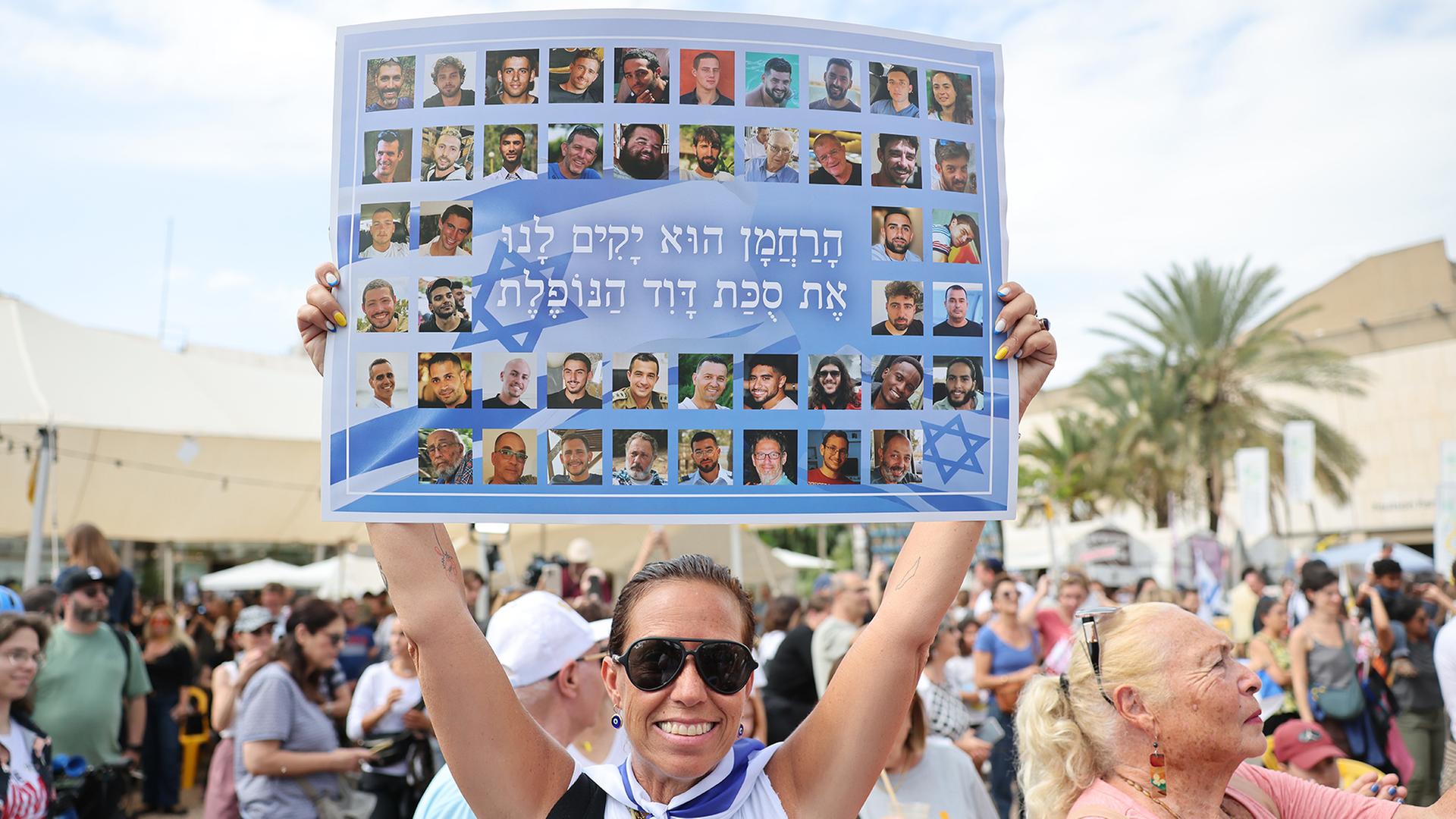 Eine Frau hält auf dem Geiselplatz in Tel Aviv ein Plakat mit Fotos von israelischen Geiseln. | EPA