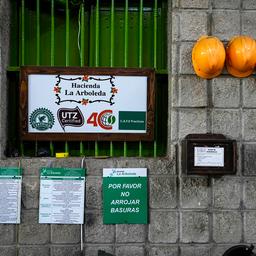 Hinweisschilder und Bauarbeiterhelme hängen an einer Wand. Ein Schild trägt die Aufschrift "Hacienda la Arboleda".