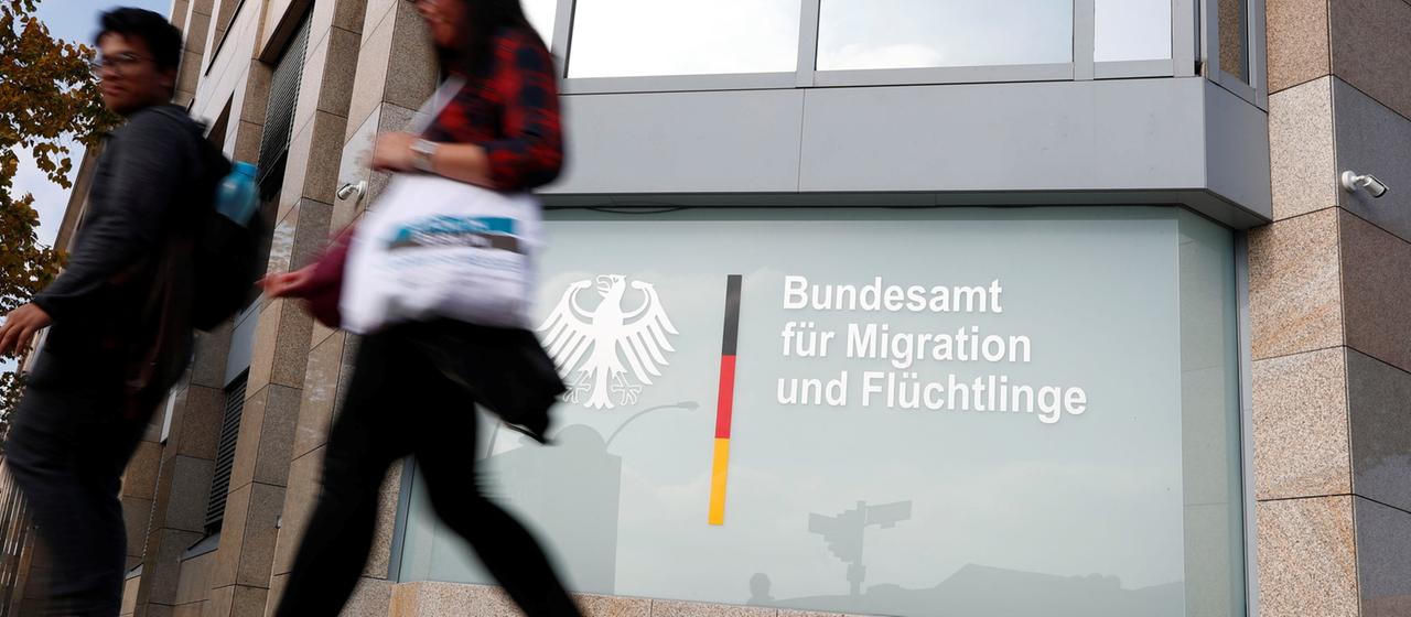 Passanten vor einer Zweigstelle des BAMF in Berlin.