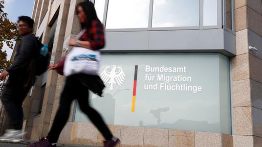 Passanten vor einer Zweigstelle des BAMF in Berlin.
