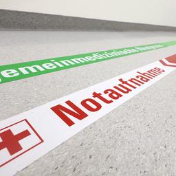 Ein Wegweiser leitet in einem Klinikum zur Notaufnahme.