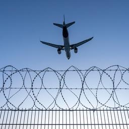 Symbolbild:Ein Flugzeug startet über einen Zaun mit Stacheldraht.(Quelle:picture alliance/J.Tack)