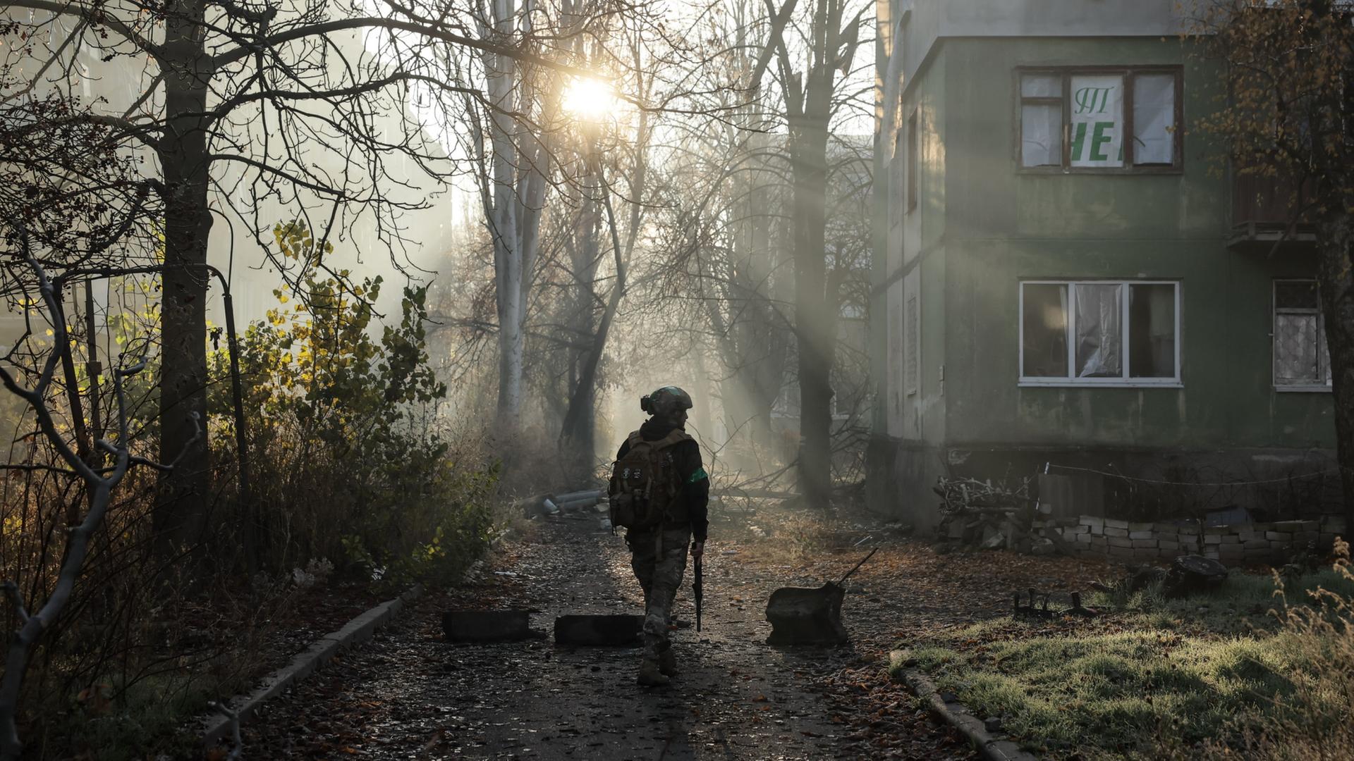 Ukrainischer Soldat vor Bäumen und Wohnhaus. | AP