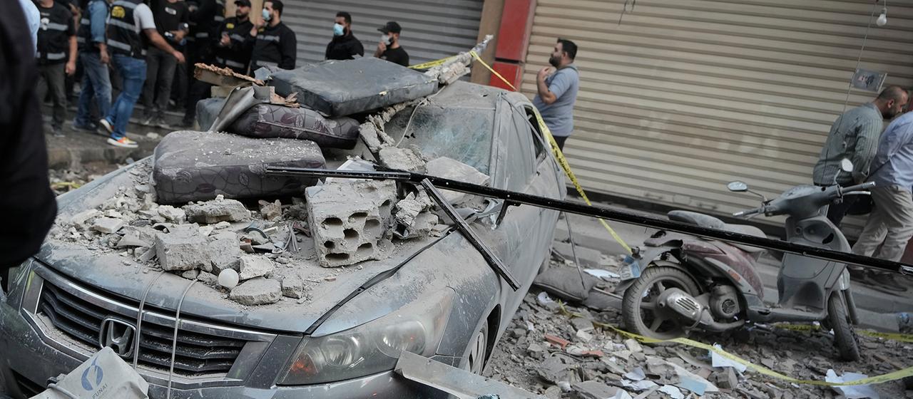 Sicherheitskräfte stehen neben einem beschädigten Auto in Beirut