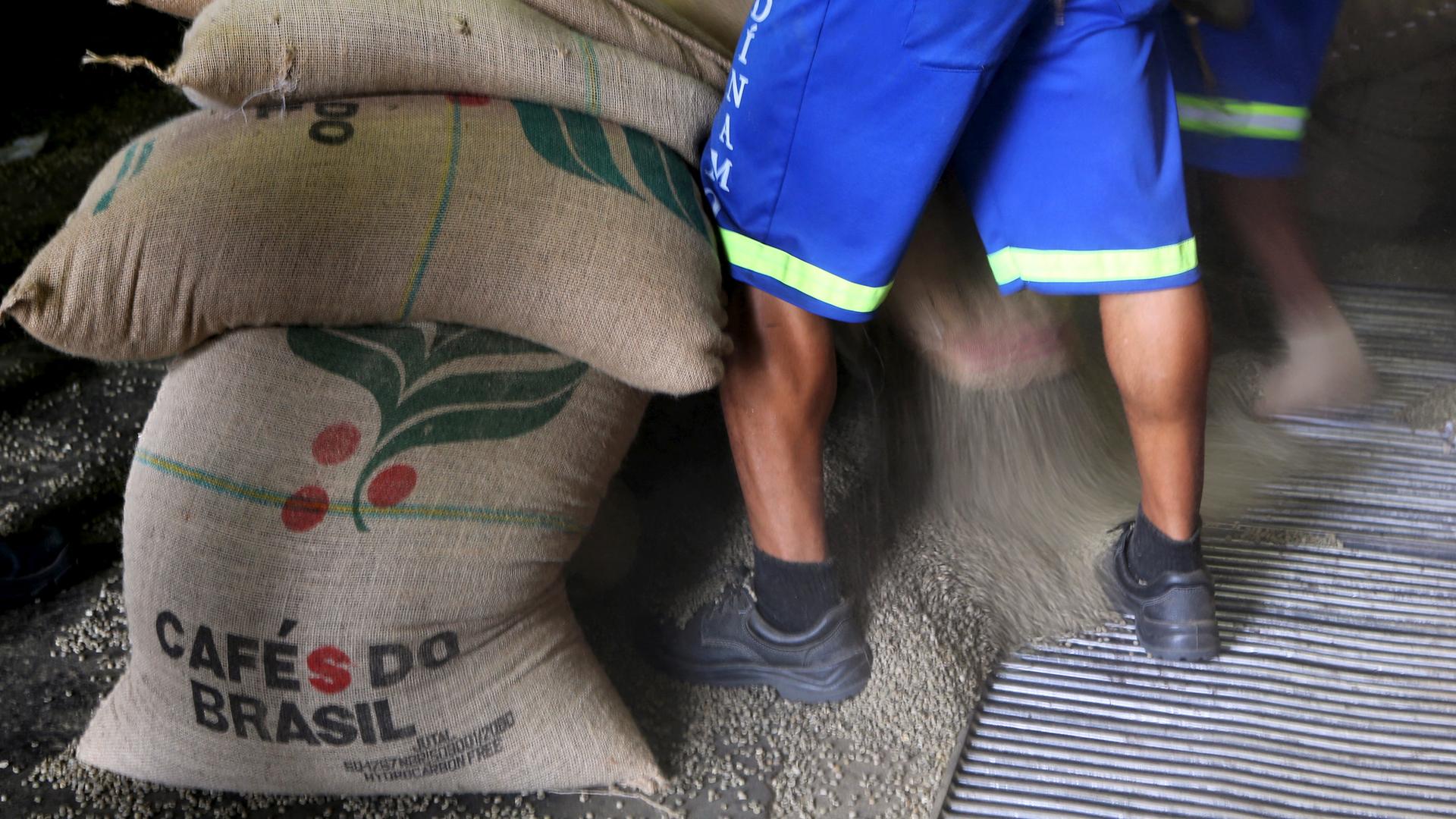 Ein Mann steht neben Säcken mit Kaffeebohnen aus Brasilien | REUTERS