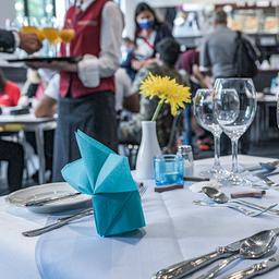 Auszubildende der Brillat-Savarin-Schule sind in einem Gastraum zu sehen.