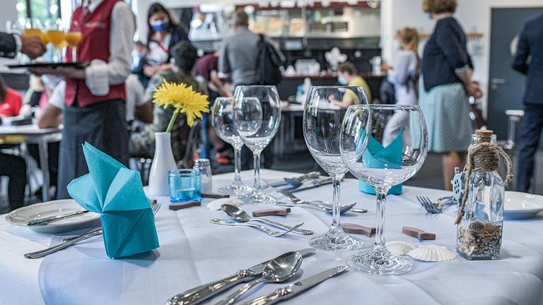 Auszubildende der Brillat-Savarin-Schule sind in einem Gastraum zu sehen.