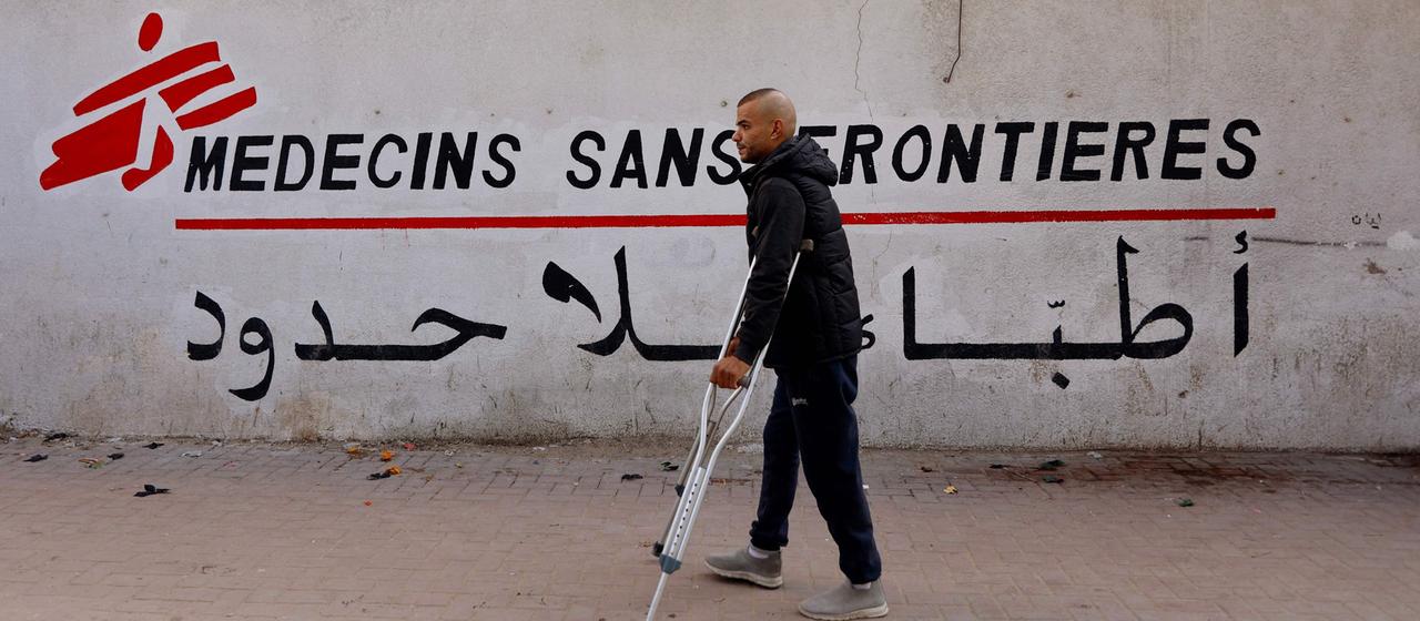 Mann im Gazastreifen geht an einem Schriftzug "Medesins sans frontieres" vorbei