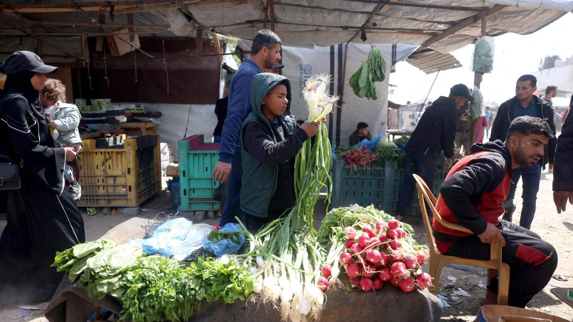 Menschen kaufen auf einem Markt in der Stadt Khan Yunis im südlichen Gazastreifen ein. | AFP