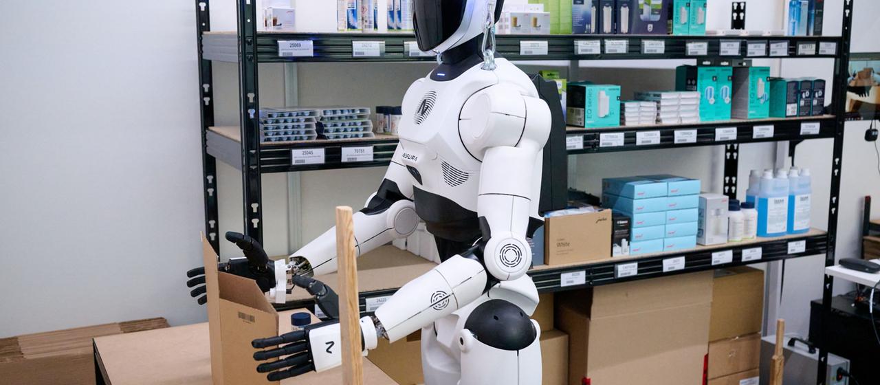 Ein weiß-schwarzer Roboter arbeitet an einem Tisch.