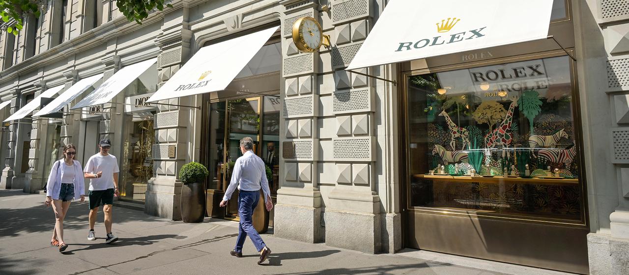 Passanten gehen eine Straße in Zürich entlang.