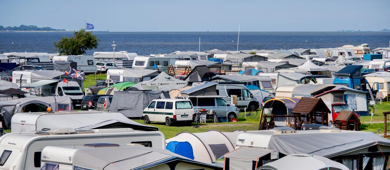 Wohnmobile und Zelte stehen auf einem Campingplatz in Dangast an der Nordsee.