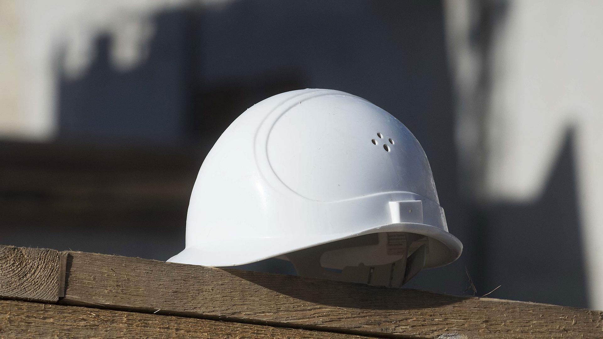 ein Schutzhelm auf einer Holzplanke | IMAGO / Depositphotos