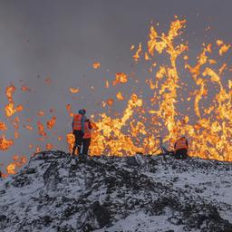Wissenschaftler der Universität von Island nehmen Messungen und Proben, während sie auf dem Kamm vor dem aktiven Teil der Eruptionsspalte eines aktiven Vulkans in Grindavik auf der isländischen Halbinsel Reykjanes stehen. 