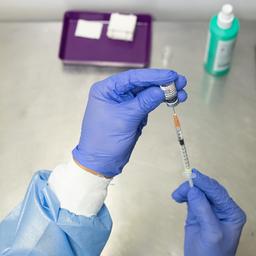 Ein Mitarbeiter zieht eine Spritze mit einem Impfstoff gegen Corona auf.