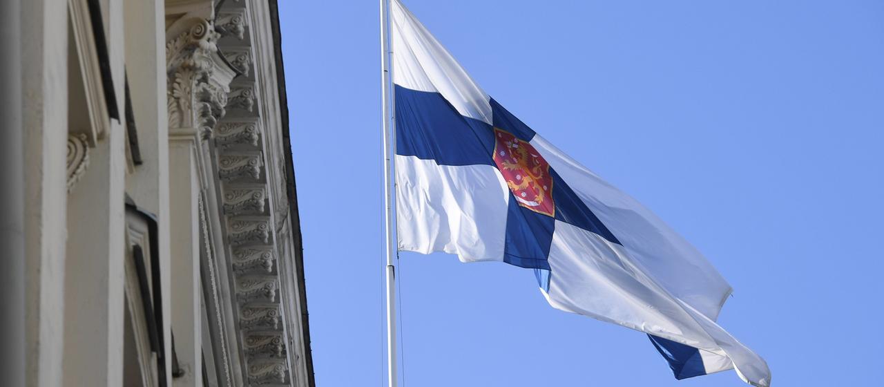 Die finnische Flagge vor dem Regierungsgebäude in Helsinki.