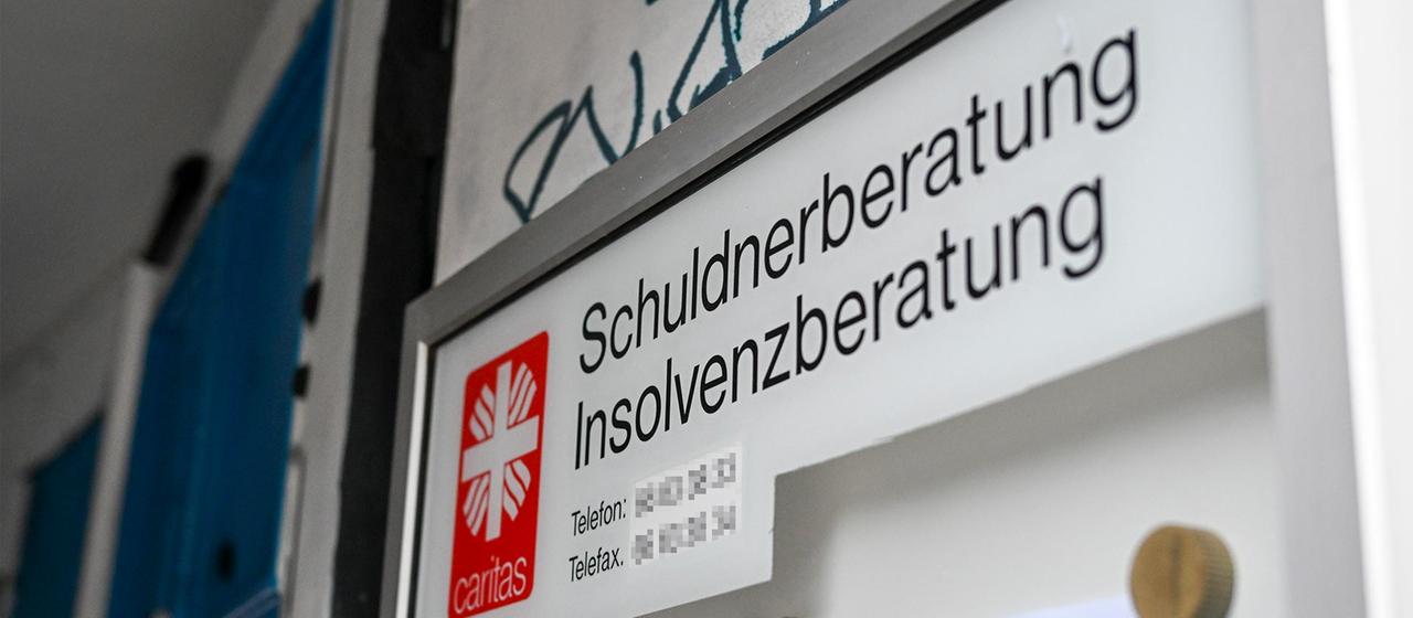 Hinweisschild einer Schuldner- und Insolvenzberatung der Caritas.