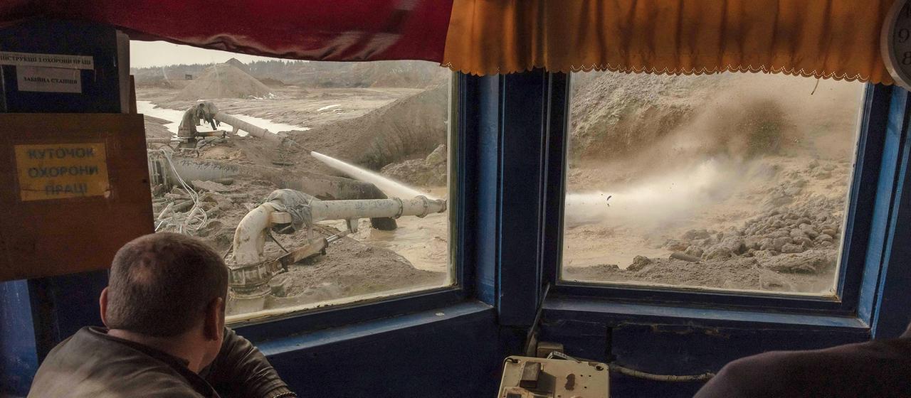 Menschen steuern eine Tagebau-Maschine in der ukrainischen Region Schytomyr.