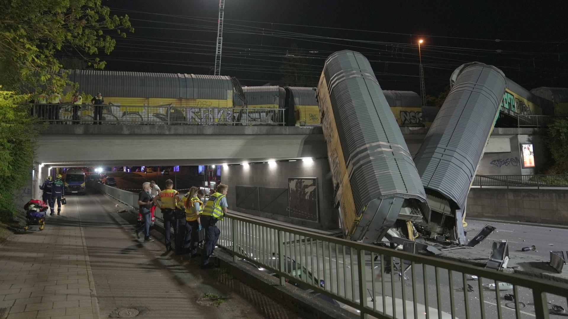 Zwei Waggons eines Güterzugs liegen auf einer Straße, nachdem sie von einer Brücke gestürzt sind | Ehsan Monajati/dpa