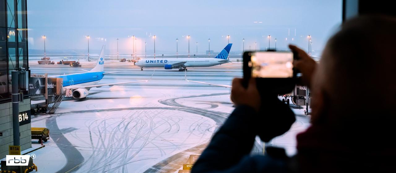 Ein Flugzeug steht auf der verschneiten Start- und Landebahn des BER in Berlin