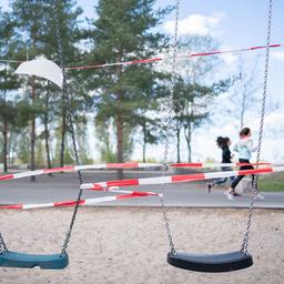 Zwei Joggerinnen laufen an abgesperrten Schaukeln im Schöneberger Südgelände vorbei.