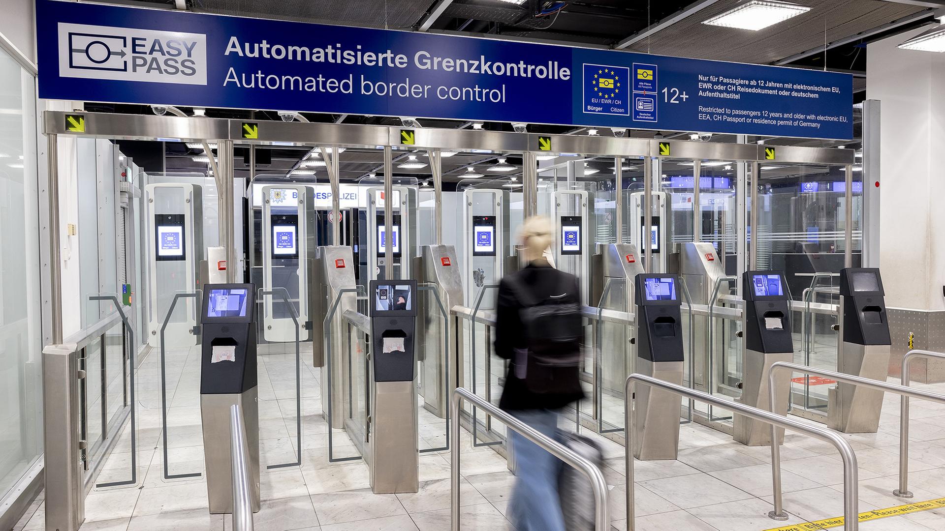 Eine Frau auf einem Flughafen geht durch eine Kontrollschranke. | Andreas Wiese/Flughafen Dsseldorf/dpa