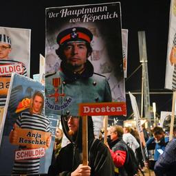 Demonstranten der "Querdenken"-Bewegung halten Schilder in die Höhe.