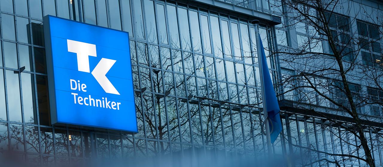 Das Logo der Techniker Krankenkasse ist an einer Hausfassade zu sehen.