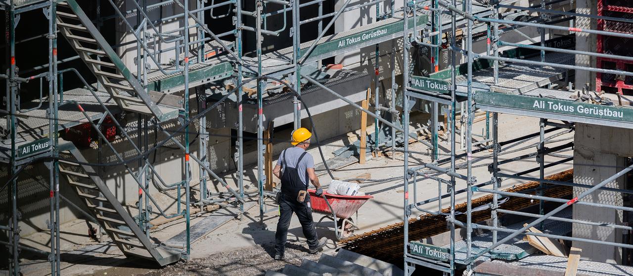 Ein Bauarbeiter arbeitet an einem Rohbau für Eigentumswohnungen.