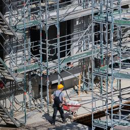 Ein Bauarbeiter arbeitet an einem Rohbau für Eigentumswohnungen.