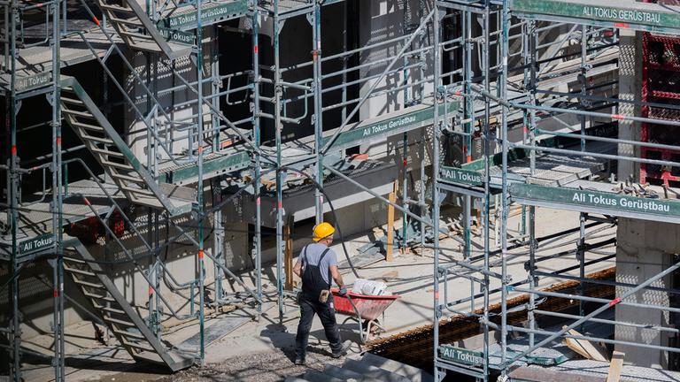 Ein Bauarbeiter arbeitet an einem Rohbau für Eigentumswohnungen.
