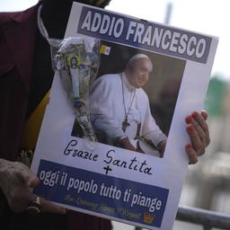 Eine Frau hält ein Bild von Papst Franziskus in den Händen. Darauf steht auf Italienisch: "Lebe wohl, Franziskus. Danke. Heute weinen alle Menschen um dich."