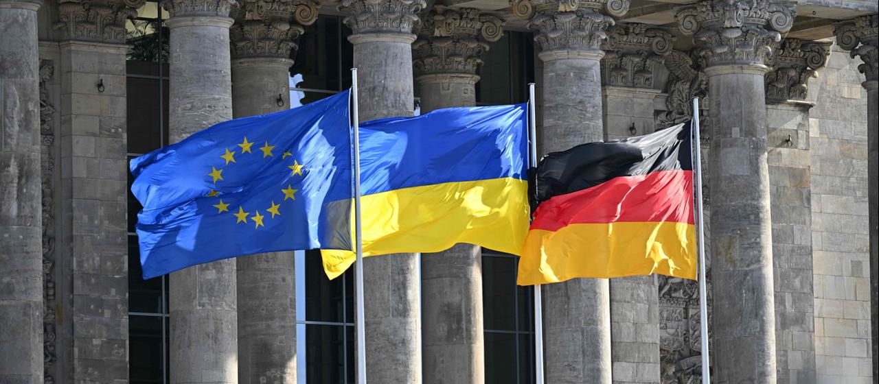 Die Flaggen der EU, der Ukraine und Deutschlands wehen vor dem Reichstagsgebäude in Berlin (Archivbild)