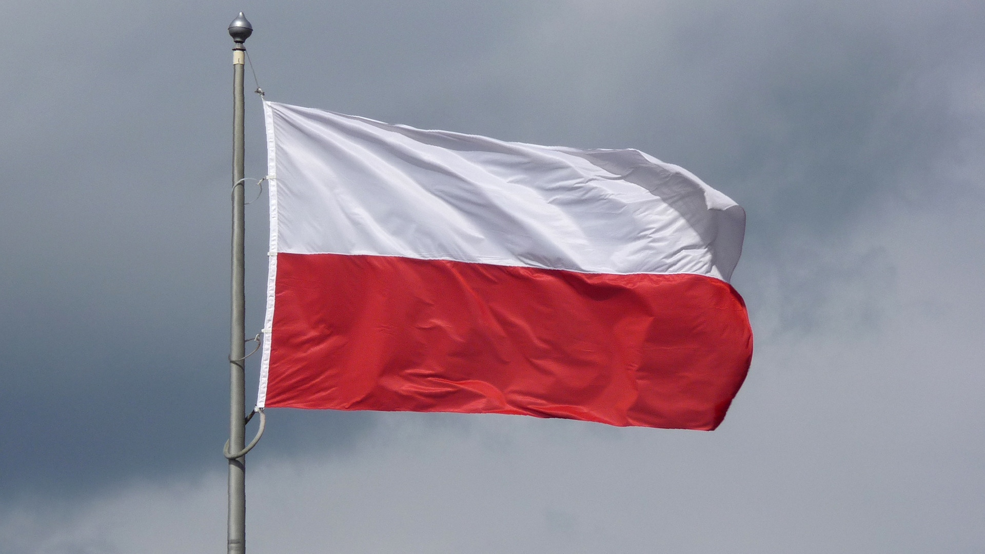Die polnische Flagge weht vor bedecktem Himmel im Wind. | picture alliance / Beate Schleep