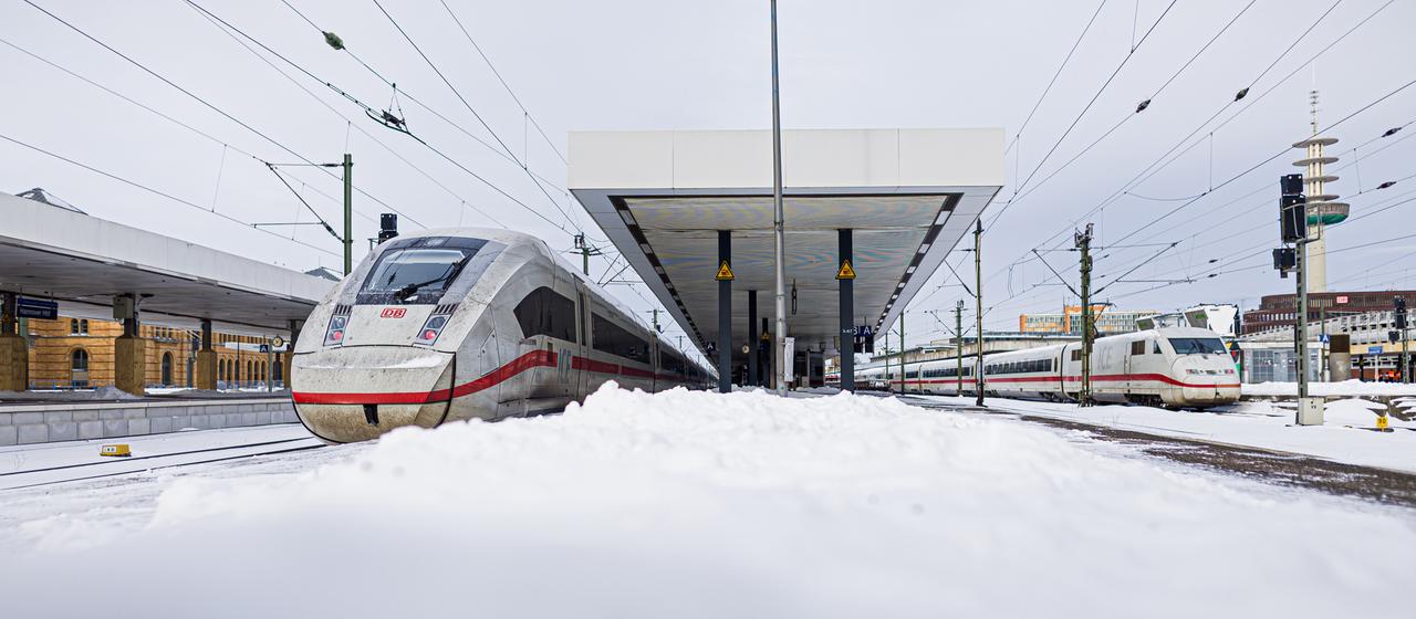 Zwei ICE stehen im verschneiten Hauptbahnhof in Hannover.