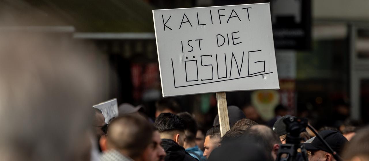 Teilnehmer einer islamistischen Demonstration in Hamburg halten ein Plakat mit der Aufschrift in der Hand 