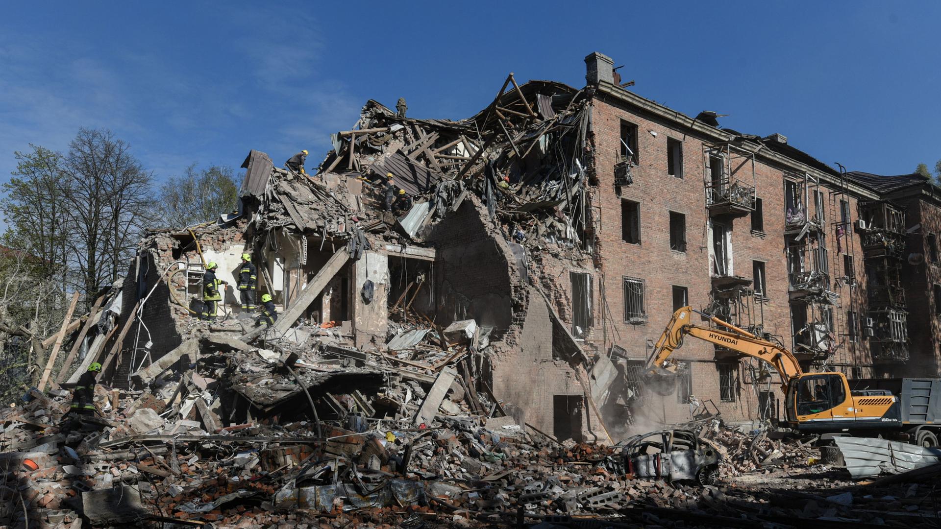 Bagger vor zerstörtem Haus in Dnipro | AP