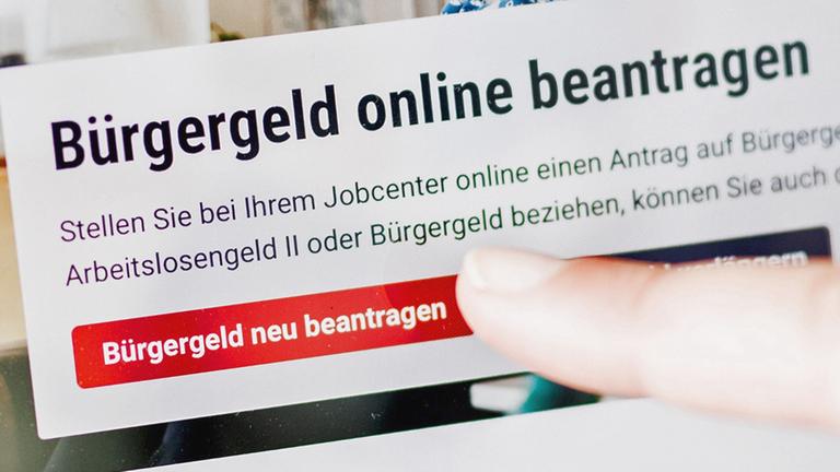 Eine Frau tippt auf einem Tablet auf einen Link zum Beantragen des Bürgergeldes