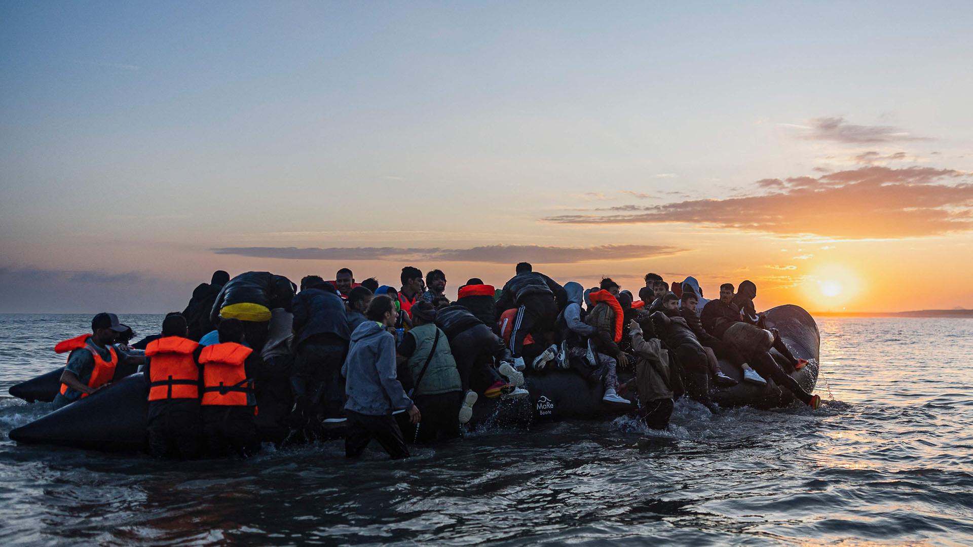Migranten versuchen in ein Schlauchboot zu steigen, um den Ärmelkanal vor dem Strand von Gravelines in Nordfrankreich zu überqueren. | AFP