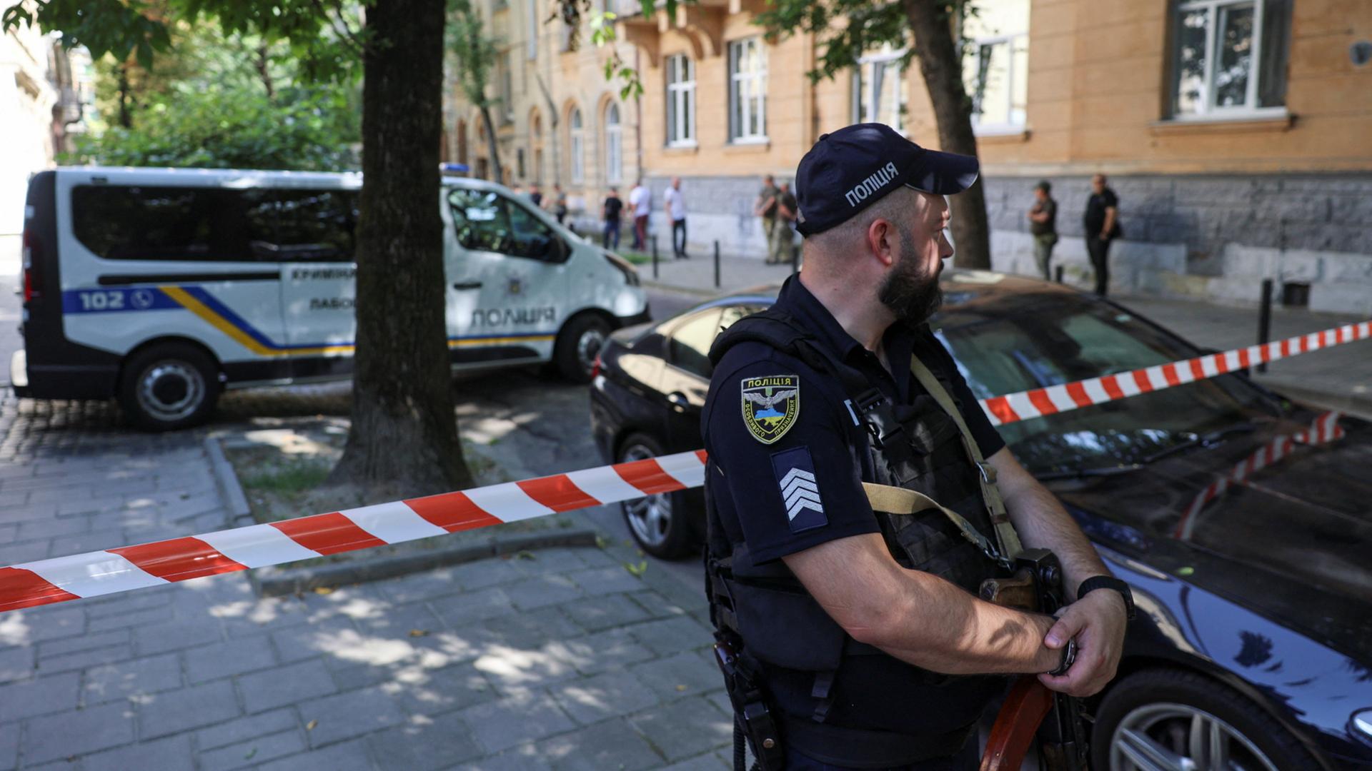 Ein Polizist steht nach dem Mord am ukrainischen Ex-Politiker Parubij am Tatort in Lwiw. | REUTERS