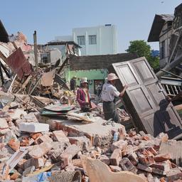 Menschen in Myanmar stehen nach dem schweren Erdbeben zwischen Trümmern. 