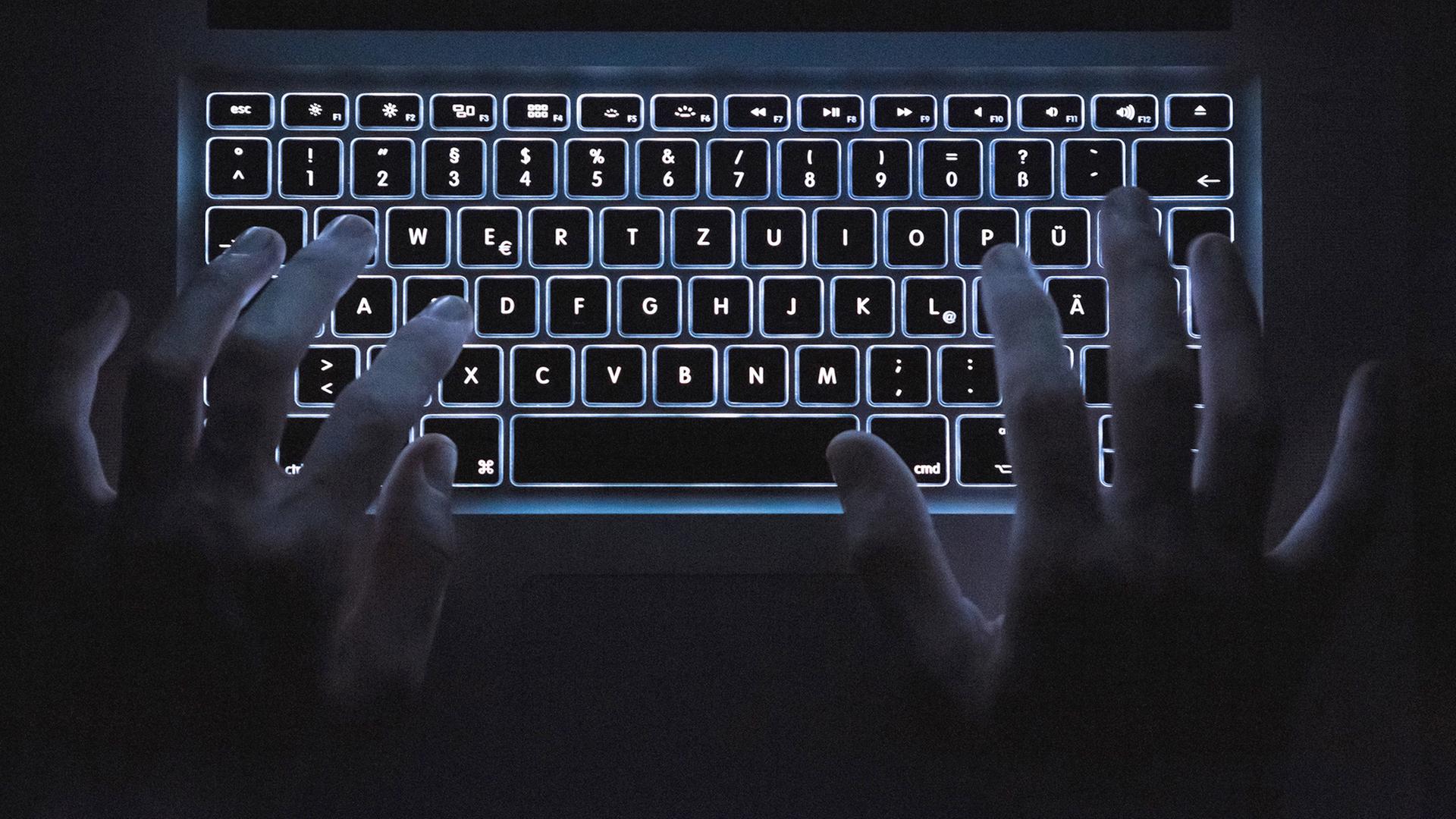 Ein Mann benutzt die beleuchtete Tastatur eines Notebooks. | dpa