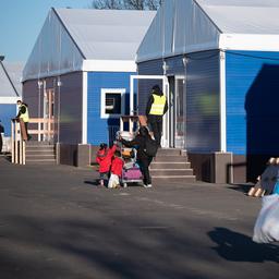 Menschen gehen an Unterkünften in der Erstaufnahmeeinrichtung des Landes Hessen für Geflüchtete in Gießen vorbei.