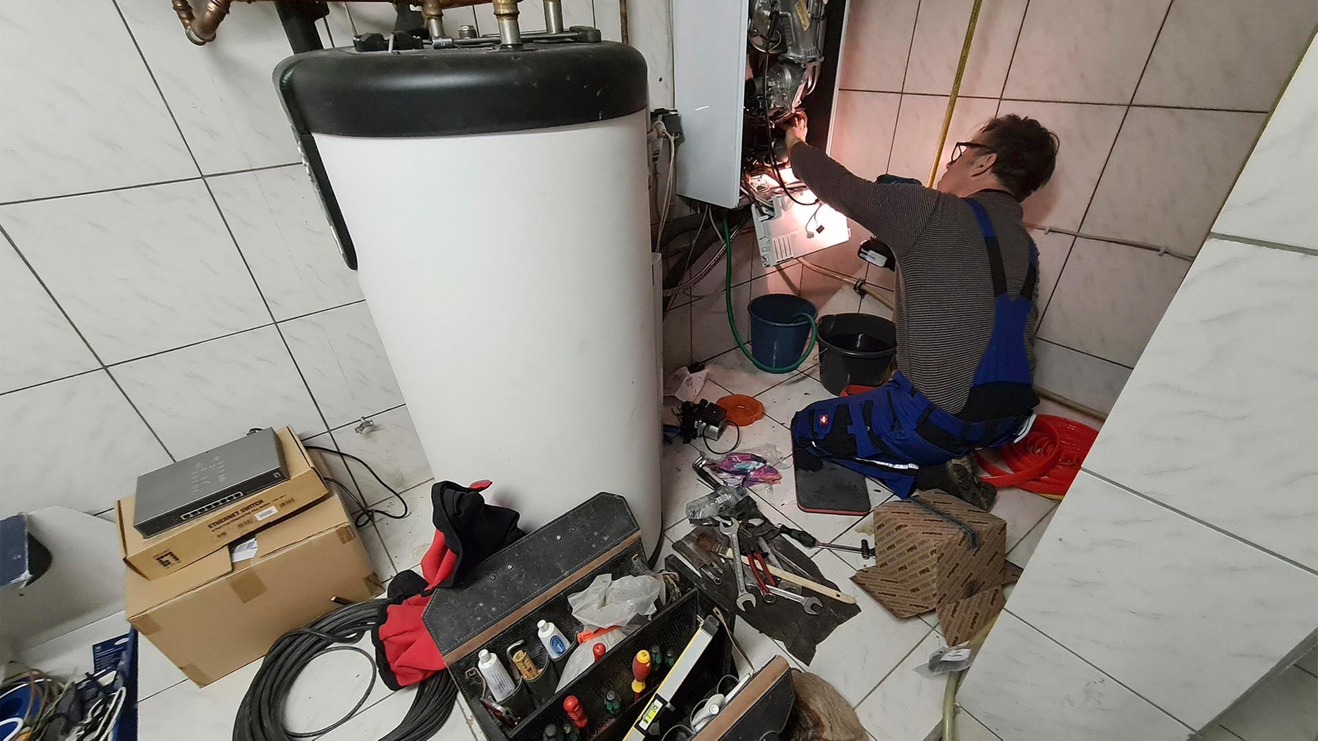 Ein Handwerker bei der Wartung einer Gastherme. | picture alliance / blickwinkel/f