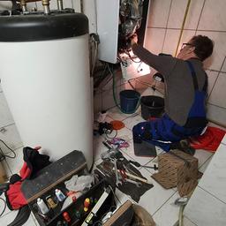 Ein Handwerker bei der Wartung einer Gastherme.